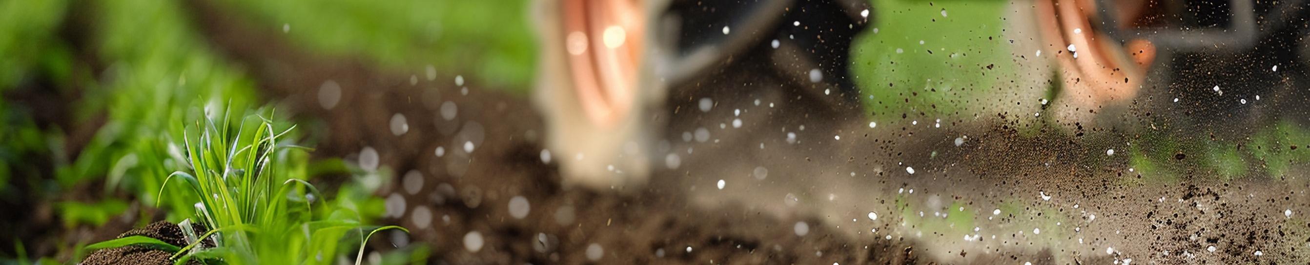 detail of a tractor spreading fertilisers in a field