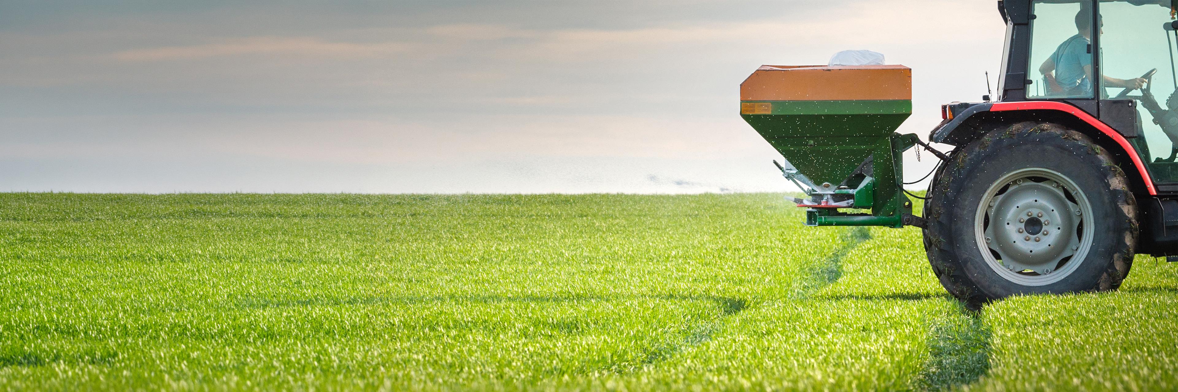 a tractor in a green field spraying the crops